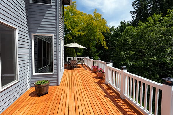 A long deck on the back of a home, made of pressure-treated wood and vinyl raillings