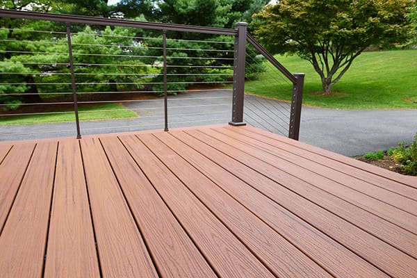 A long deck on the back of a home, made of pressure-treated wood and vinyl raillings