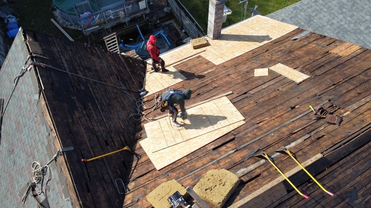 Workers putting new ply on a residential roof