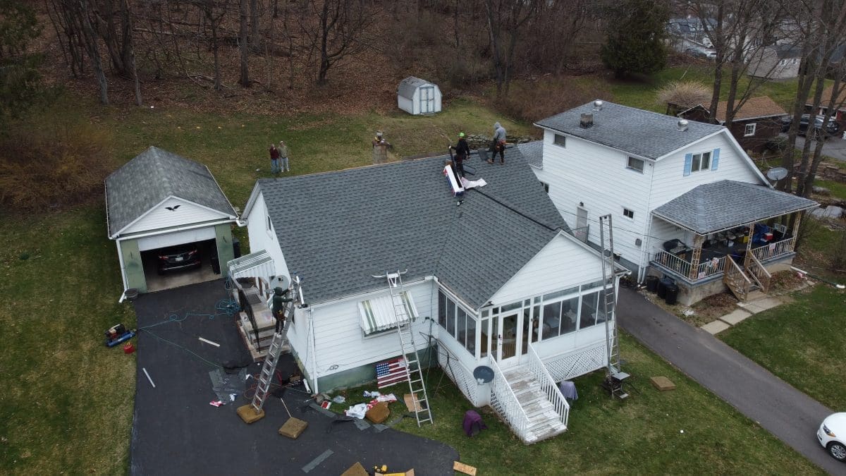 Workers on a residential roof are preparing to finish their work.