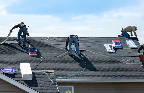 three men working on a roof